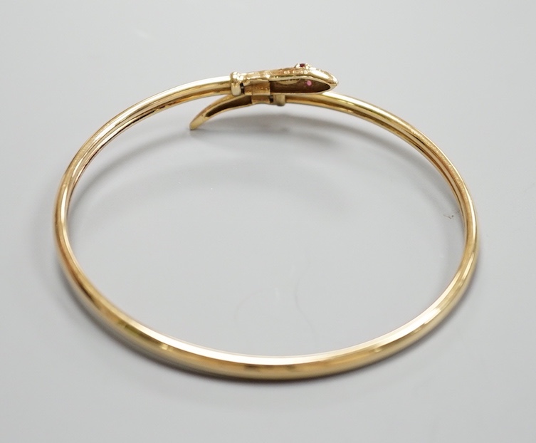 A modern 375 and gem set serpent bangle, 11.3 grams.